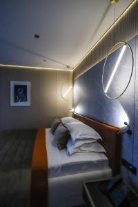 a bedroom with a bed with two lights on it at Hotel Medistone in Omiš