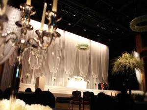 テジョンにあるHotel Sunshineの白いカーテンと椅子、シャンデリアが備わる舞台