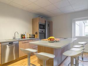 a kitchen with a counter with stools in it at Seydisfjördur Guesthouse in Seyðisfjörður