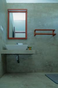 een badkamer met een witte wastafel en een spiegel bij Traveller's Hotel Hikkaduwa in Hikkaduwa