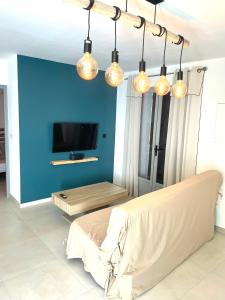 a living room with a couch and a blue wall at Mini maison entre mer et montagne in Aléria