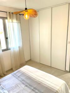 a bedroom with a bed and a ceiling fan at Mini maison entre mer et montagne in Aléria