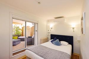 a small bedroom with a bed and a balcony at Hotel Les Pasteliers in Albi