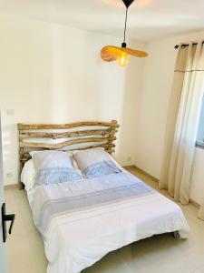 a bed with white sheets and pillows in a bedroom at Mini maison entre mer et montagne in Aléria