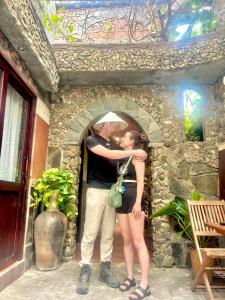 a man and a woman standing in a stone doorway at Sầm Sơn Boutique Hotel Phan Thiết in Phan Thiet