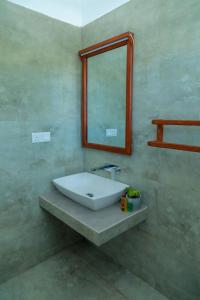 a bathroom with a sink and a mirror at Traveller's Hotel Hikkaduwa in Hikkaduwa