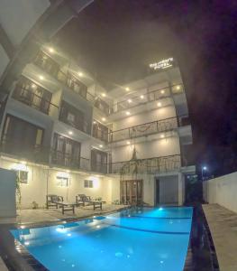 a swimming pool in front of a building at night at Traveller's Hotel Hikkaduwa in Hikkaduwa