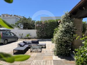 een terras met banken, een tafel en een auto bij Villa Areia - Spiaggia a 10m By Cala Salento in Porto Cesareo