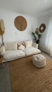 a white couch in a living room with a rug at Beach Bungalow Yeppoon in Yeppoon