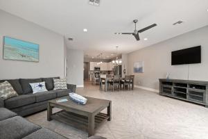 un soggiorno con un divano e un tavolo di Fortebello Beachside 156 a Indian Harbour Beach