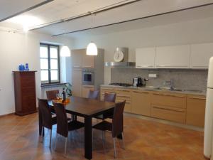 a kitchen with a dining room table and chairs at La Casa in Rivalta in Verduno