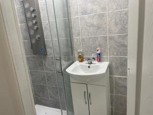 een badkamer met een wastafel en een douche bij Feltham rest place in Feltham