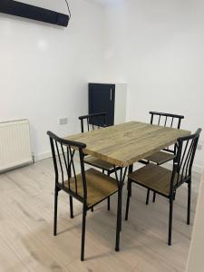 een houten tafel en stoelen in een kamer bij Feltham rest place in Feltham