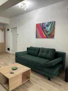 a living room with a green couch and a coffee table at Bonte Residence str Daliei nr 3 Giroc in Giroc