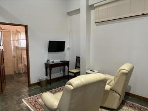 a living room with two chairs and a television at The Block Vista B&B in Nanango