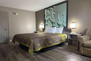 Un pat sau paturi într-o cameră la Super 8 by Wyndham Monroe