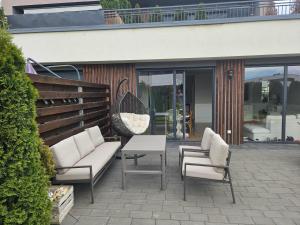 a patio with couches and a table and chairs at Przytulne mieszkanie z kominkiem in Opole