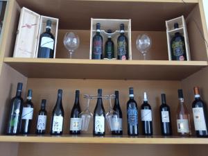 a shelf full of wine bottles and wine glasses at Hotel San Paolo in Varazze