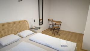 Un dormitorio con una cama y una mesa con una silla. en Ljubljana rest nest, en Liubliana