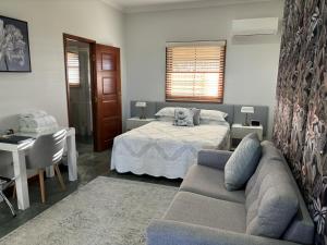 - un salon avec un lit et un canapé dans l'établissement The Block Vista B&B, à Nanango