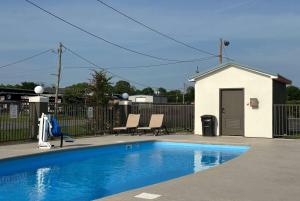a swimming pool with two chairs next to a fence at Super 8 by Wyndham Monroe in Monroe