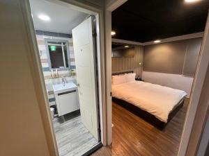 a small bedroom with a bed and a sink at Bon Hotel Taipei in Taipei