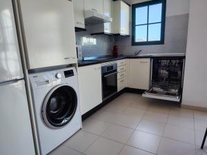 Una cocina con lavadora y secadora. en Casa Eric, en Playa Blanca