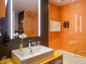 y baño con lavabo y ducha. en Mercure Hotel Köln West en Colonia