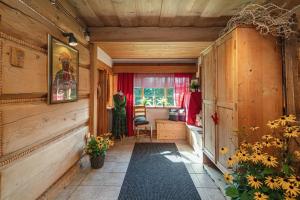 a hallway with wooden walls and a room with flowers at Apartamenty u Giewonta in Zakopane