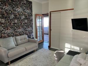 uma sala de estar com um sofá e uma televisão em The Block Vista B&B em Nanango