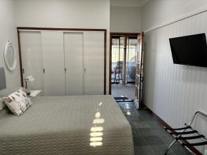 a bedroom with a bed and a flat screen tv at The Block Vista B&B in Nanango