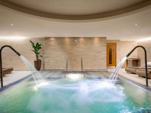 una piscina con getti d'acqua in una casa di Sofitel London Heathrow a Hillingdon
