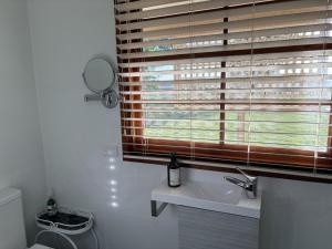 a bathroom with a window with a sink and a toilet at The Block Vista B&B in Nanango