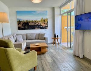 sala de estar con sofá y mesa en Apartamentos Tigaiga Suites, en Puerto de la Cruz