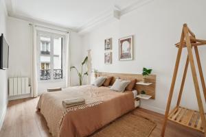- une chambre avec un grand lit et une échelle en bois dans l'établissement Villa Arc de Triomphe, à Paris