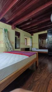 a large bed in a room with wooden ceilings at Keshava Heritage in Belūr