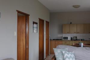 Una sala de estar con un sofá y una cocina. en Haven at Casa Esda, en Jeffreys Bay