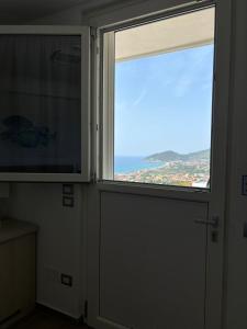 uma porta com uma janela e vista para o oceano em Miramare Castellabate Resort em Santa Maria di Castellabate