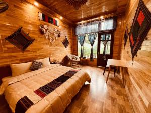 um quarto com uma cama num quarto com paredes de madeira em Sapa Pomu Home em Sa Pa