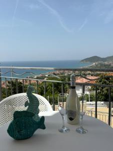 una mesa con una botella de vino y un pescado verde. en Miramare Castellabate Resort, en Santa Maria di Castellabate