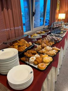 een buffet met veel verschillende soorten gebak en borden bij Hotel Maja in Pescara