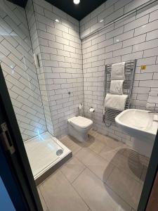 a white bathroom with a toilet and a sink at Best Western Rockingham Forest Hotel in Corby