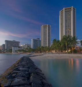 eine Skyline der Stadt in der Nacht mit Strand und Gebäuden in der Unterkunft Hyatt Regency Waikiki Beach Resort & Spa in Honolulu