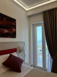 um quarto de hotel com uma cama e uma porta de vidro deslizante em Miramare Castellabate Resort em Santa Maria di Castellabate