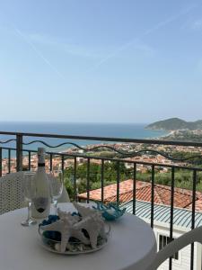 a table with a wine bottle and glasses on a balcony at Miramare Castellabate Resort in Santa Maria di Castellabate