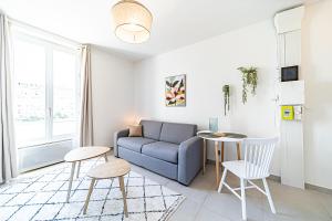 a living room with a couch and a table at Le Petit Clément - Charmant et Cosy in Villeurbanne