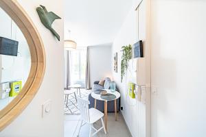 a small dining room with a table and a mirror at Le Petit Clément - Charmant et Cosy in Villeurbanne