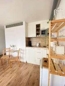 a kitchen with white cabinets and a table and a ladder at Cozy studio on the roof, next to Incheba Expo in Bratislava