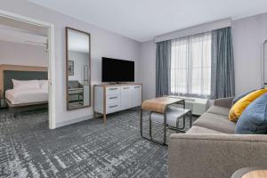 ein Hotelzimmer mit einem Bett und einem TV in der Unterkunft Homewood Suites - Rock Springs in Rock Springs