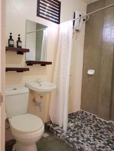a bathroom with a toilet and a sink and a shower at Solana Siargao in Catagnan